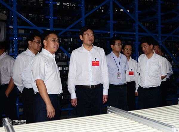 國軒高科董事長李縝正在向省委常委、宣傳部長曹征海（左二）介紹電池工藝流程 