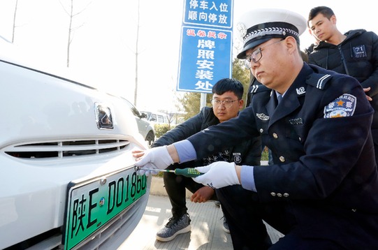 陜西民警正向消費者發放新能源汽車專用號牌