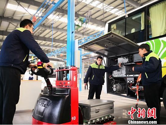 圖為工作人員在給新能源車輛安裝蓄電池。魏建軍 攝